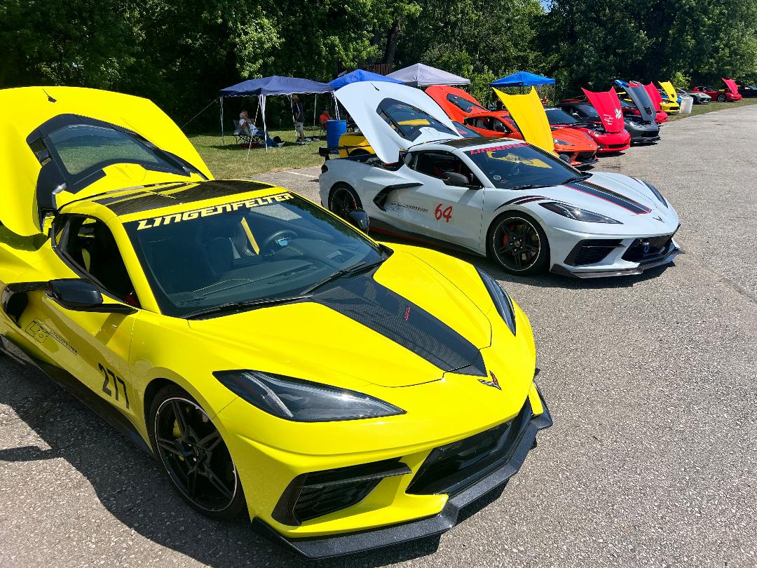 Kristen Lingenfelter Track Day featuring yellow and white Corvettes parked under canopies at the Oval Ring.