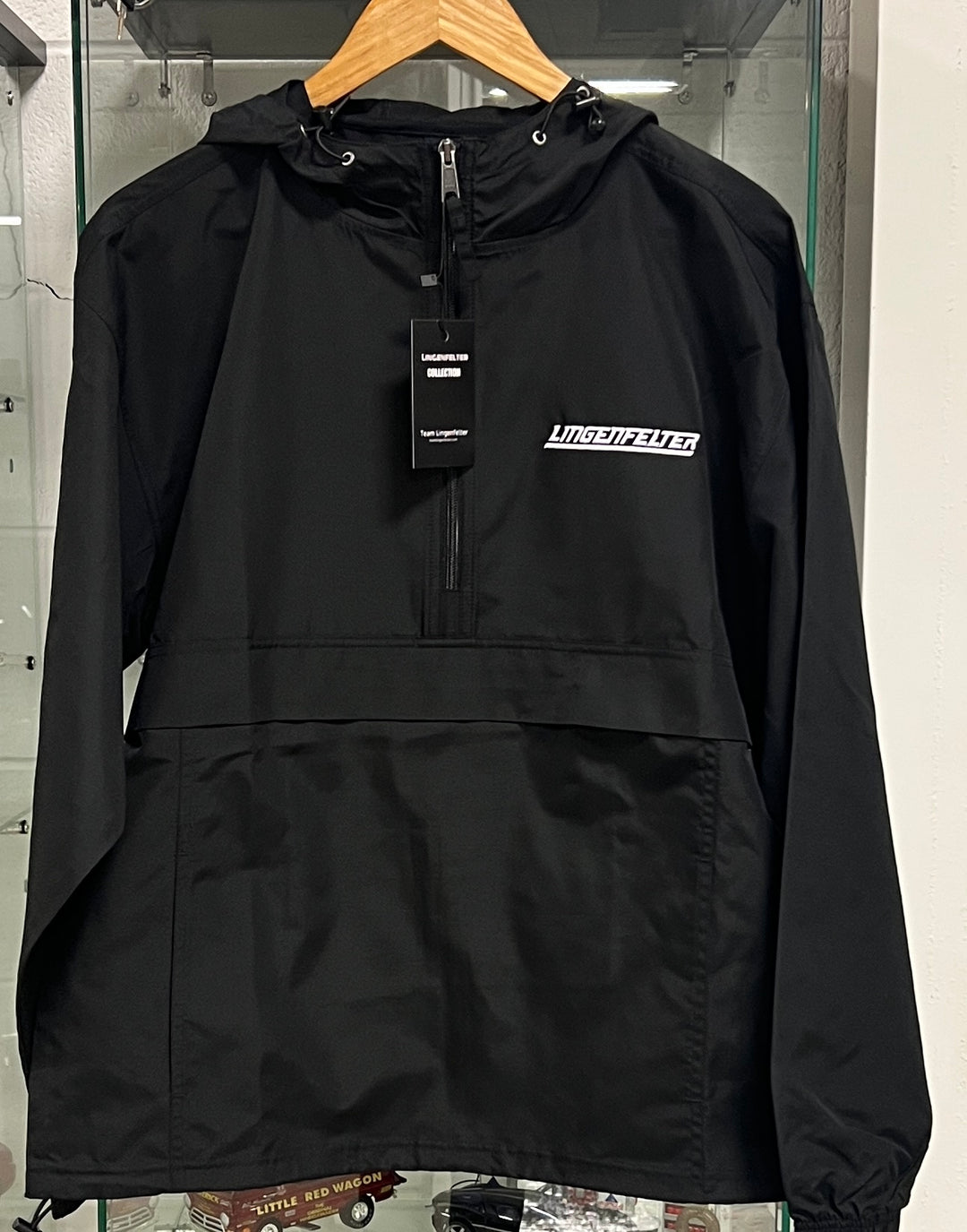 Lingenfelter men's packable windbreaker jacket in lightweight, breathable fabric, shown folded and partially unfolded.