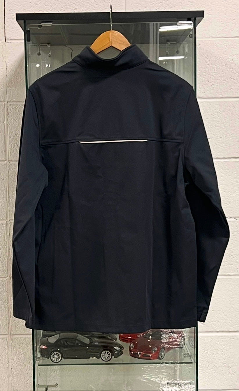 Black jacket on a hanger against a white tiled wall.