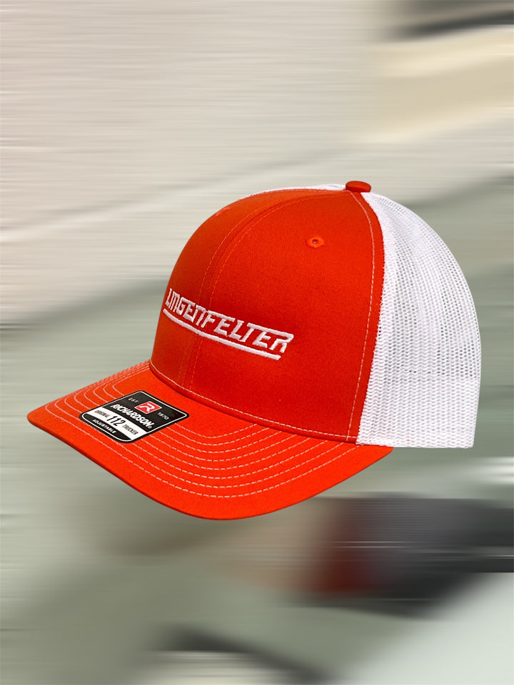 Orange and white cap with a brand logo on a blurred background