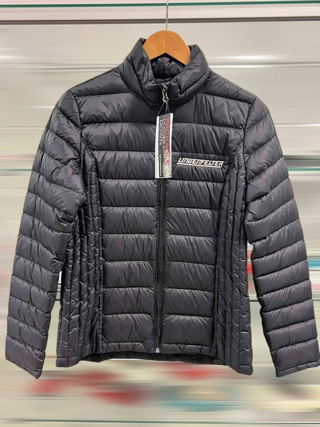 black puffer jacket on a hanger with a blurred background