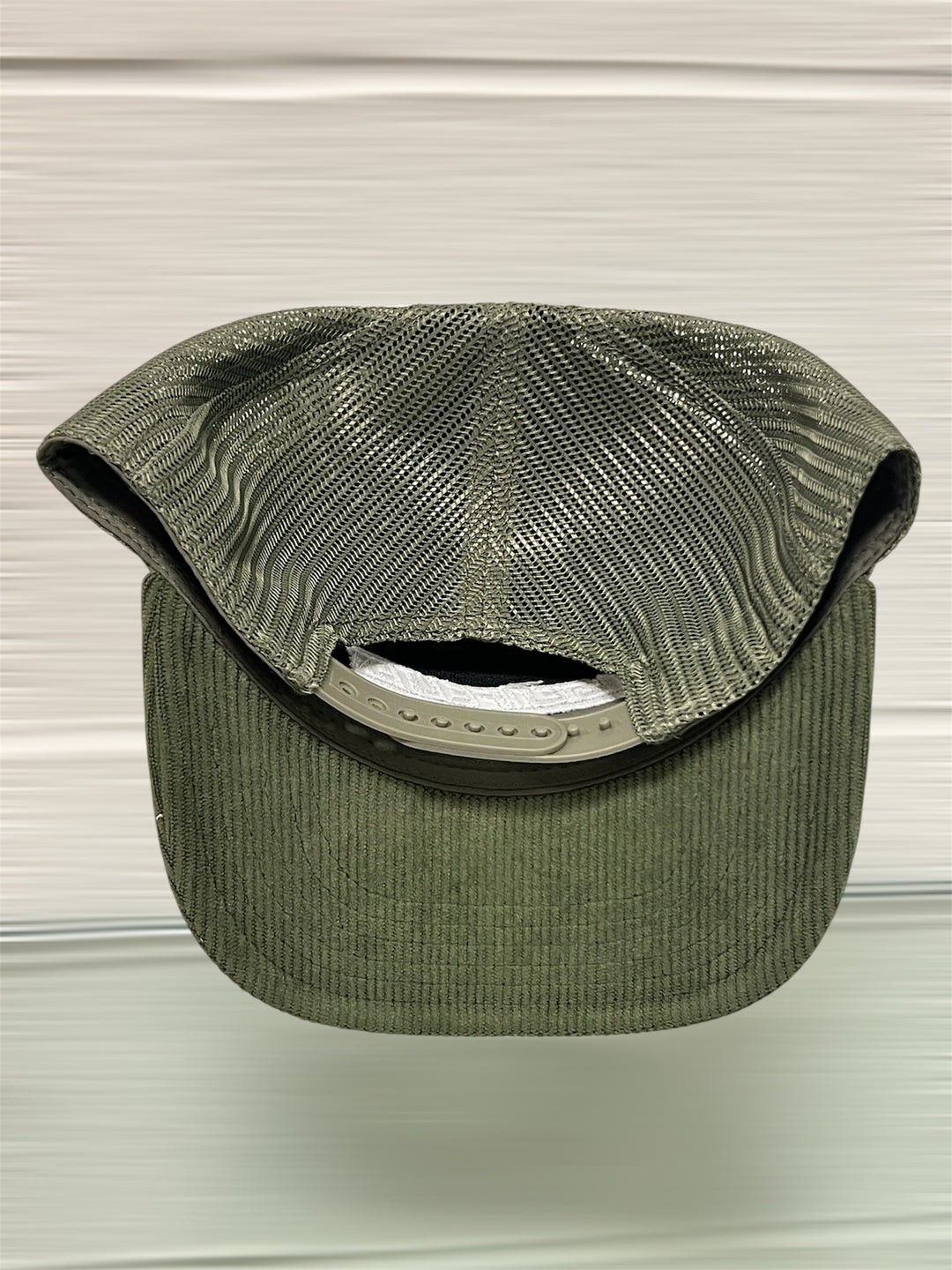 Green visor cap on a light gray background