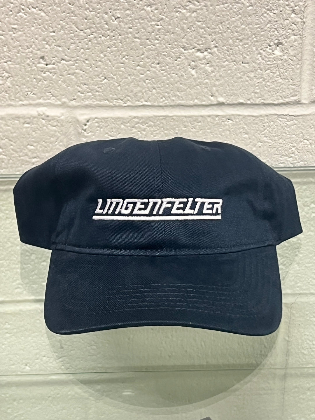 Navy blue cap with 'Lingenfelter' logo on a light gray background