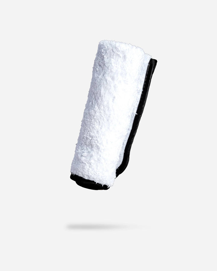 White towel with black trim on a light gray background