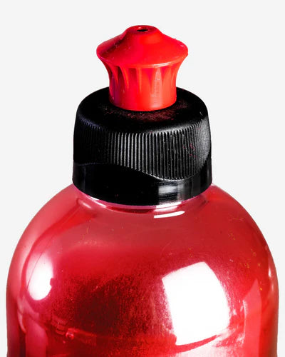 Red bottle with a black cap and red cap on a white background