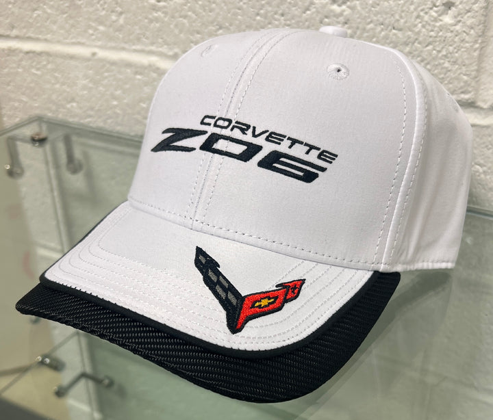 White Corvette Z06 cap with black text and logo on a glass surface.